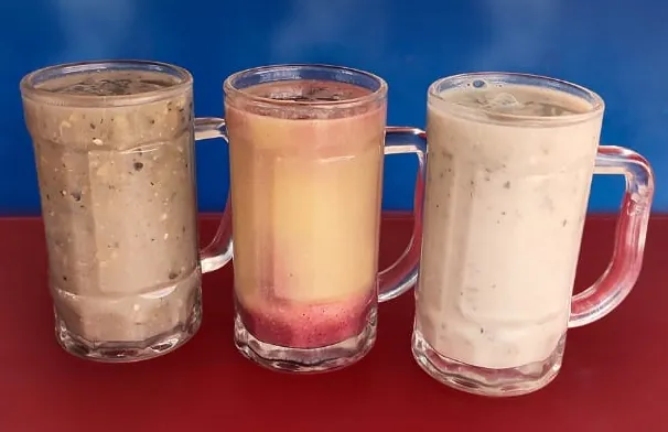 Tres jarros de bebida caliente servidos sobre una mesa